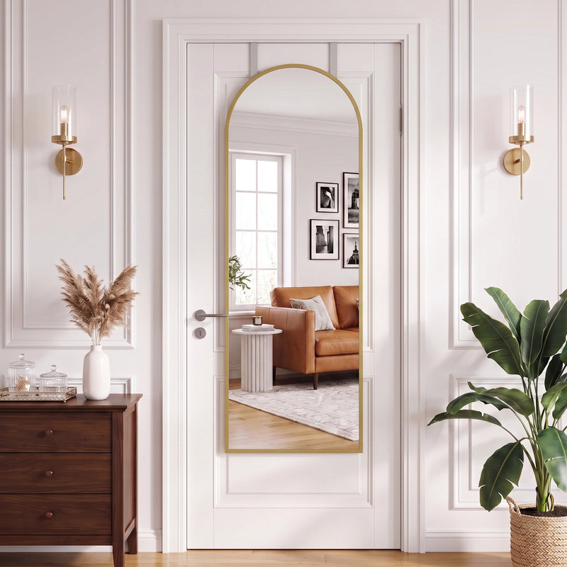 Arched mirror over a door flanked by wall lights, with a sideboard and plant