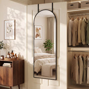 Arched mirror hanging over a door next to a walk-in wardrobe