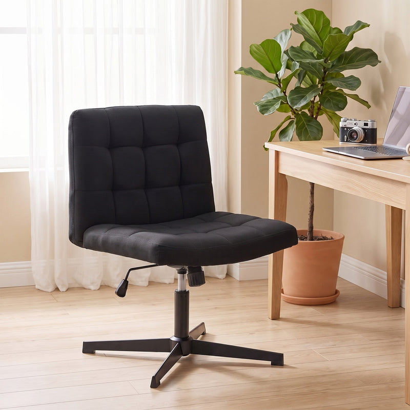 Black armless office chair in a home office setting beside a desk