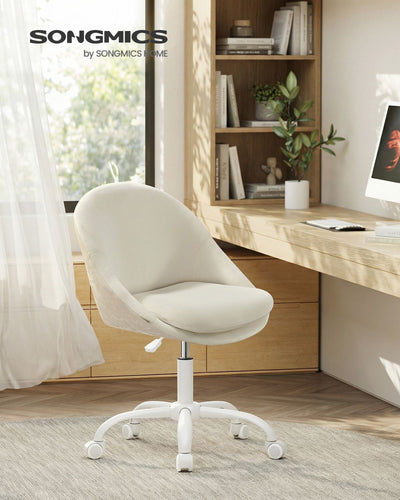 Cream white velvet chair at a wooden desk in a bright home office