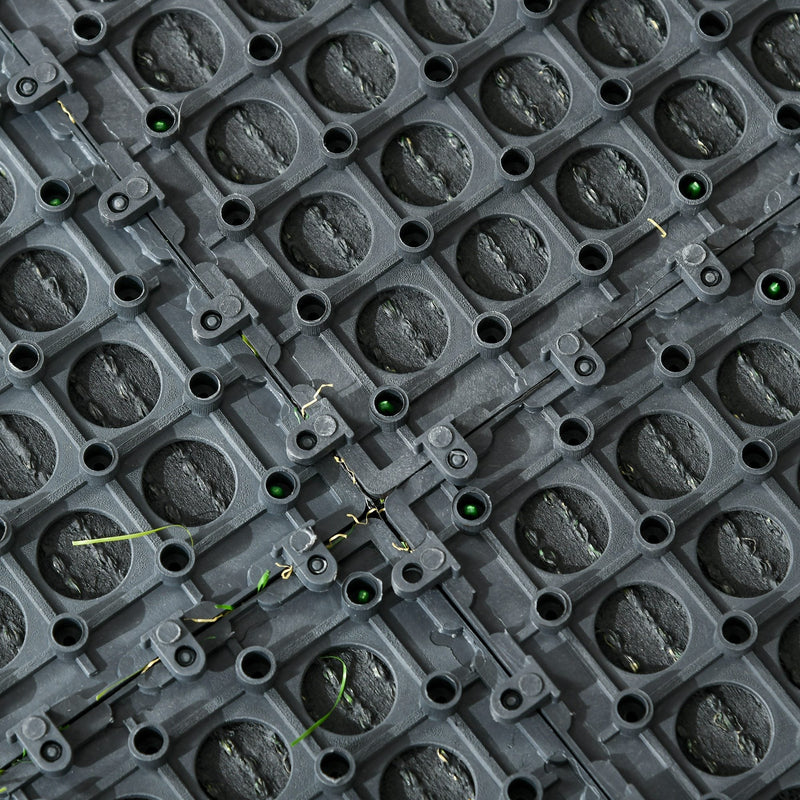 Underside close-up of the tile's snap-connect studs and drainage holes