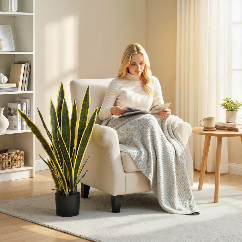 Artificial snake plant beside an armchair in a reading corner