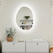 Asymmetric LED bathroom mirror, 70 x 50 cm: above a white sideboard with plants and books