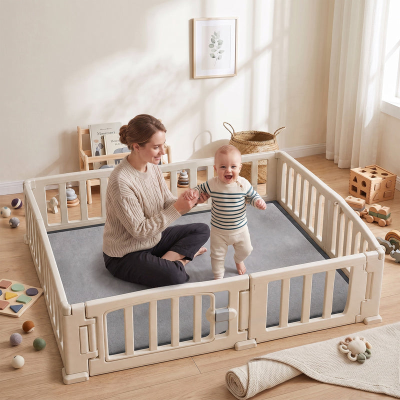 Mother and baby sitting on a dark grey play mat inside a play pen