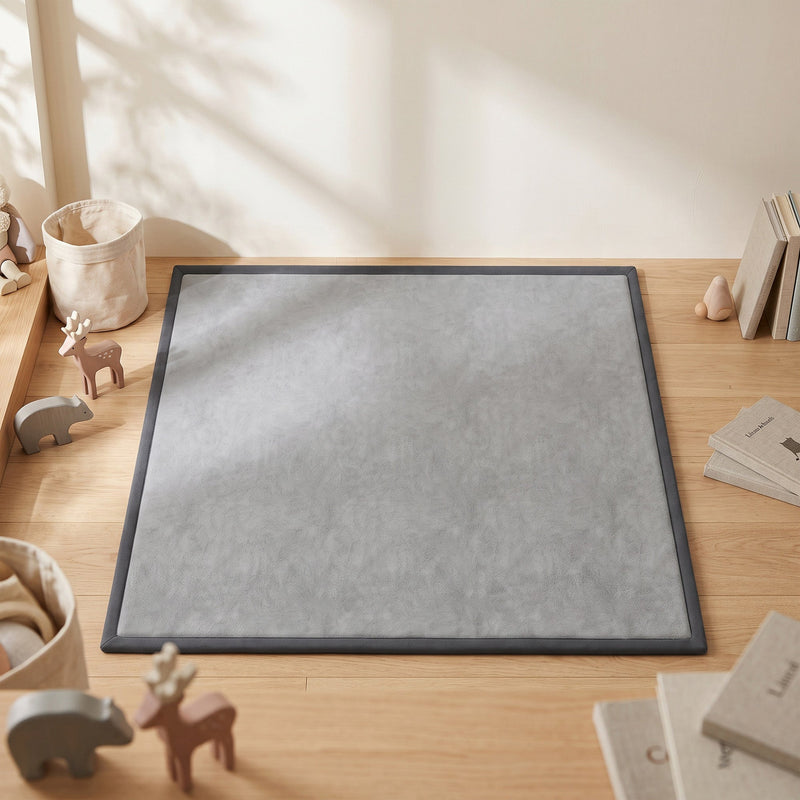 Dark grey play mat on a wooden floor in a nursery with toys