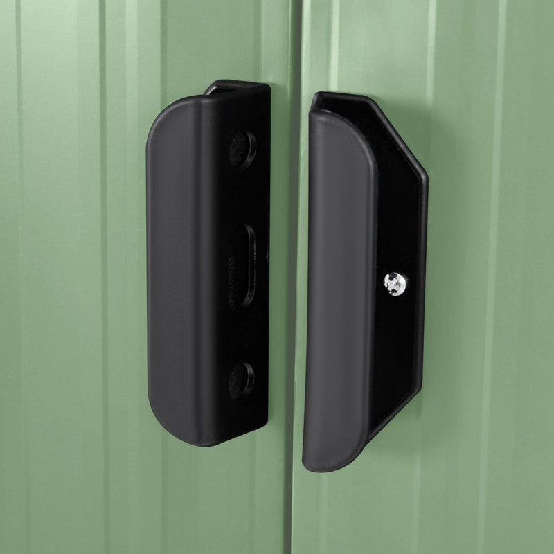 Close-up of the black door handles set against the light green sliding doors of the metal shed