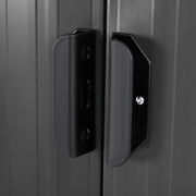 Close-up of the black sliding door handles on the metal shed, showing the slotted hasp that takes a padlock