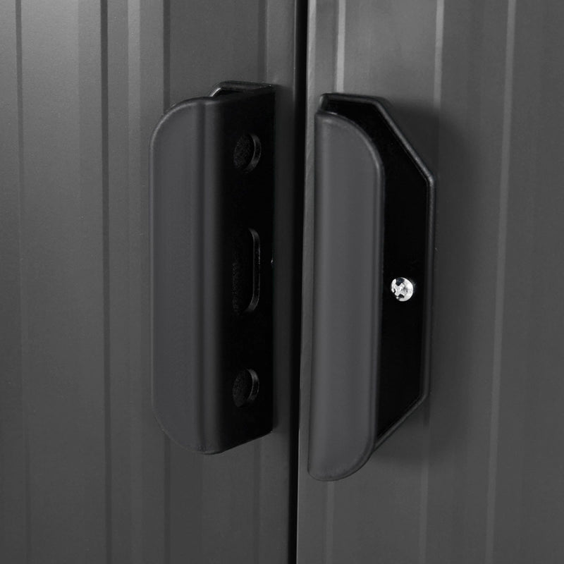Close-up of the black sliding door handles on the metal shed, showing the slotted hasp that takes a padlock