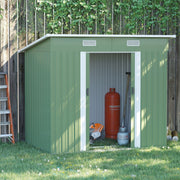 Light green Outsunny 7x4ft metal garden shed against a wooden fence with its sliding doors open on a sunny lawn