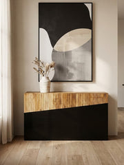 Two-tone console table styled in an entryway with a lamp and vase