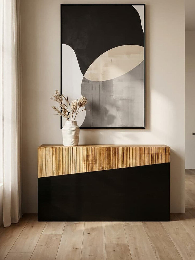 Two-tone console table styled in an entryway with a lamp and vase