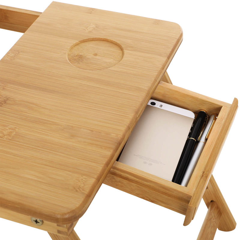 Close-up of the bamboo tabletop showing the round cup recess and the open side drawer below