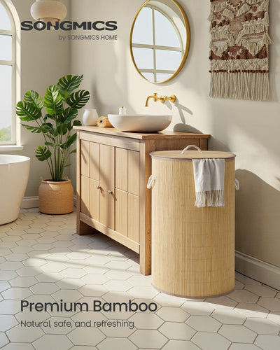 Natural bamboo laundry basket styled in a bathroom beside a vanity with a towel draped over the lid