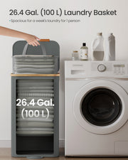 Slate grey laundry hamper standing beside a washing machine, labelled 100 litres