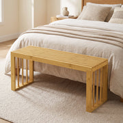 Bamboo bench at the foot of a bed in a bedroom