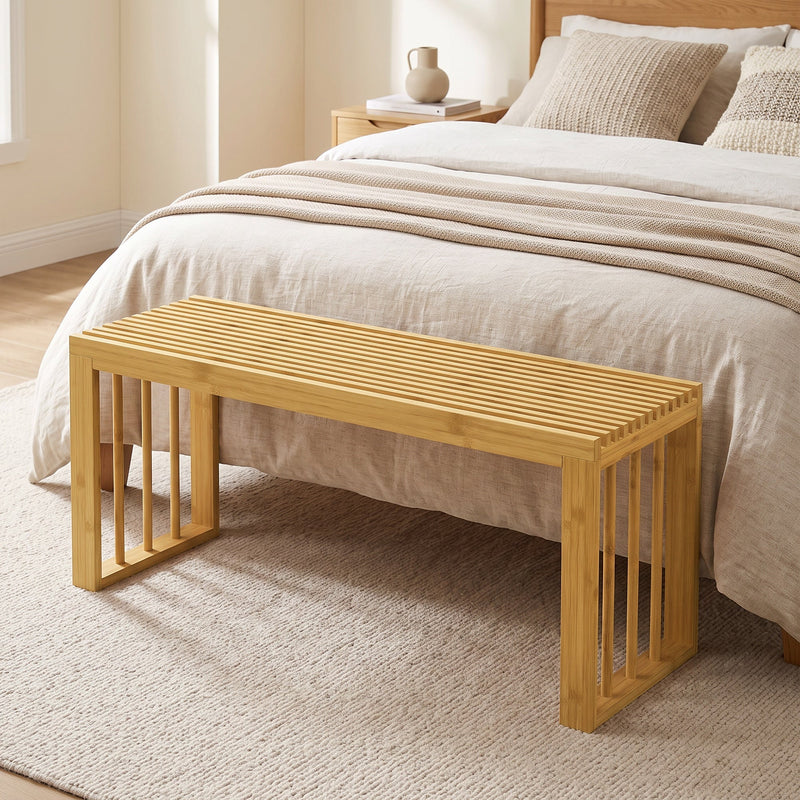 Bamboo bench at the foot of a bed in a bedroom
