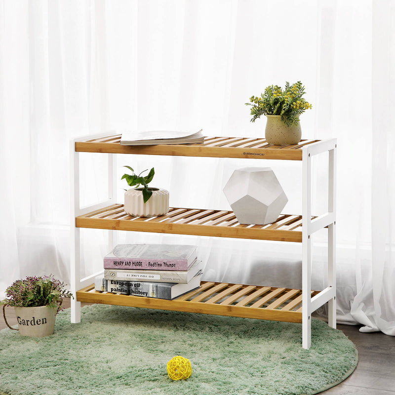 Bamboo shoe rack used as a hallway shelf with books, a vase and a potted plant