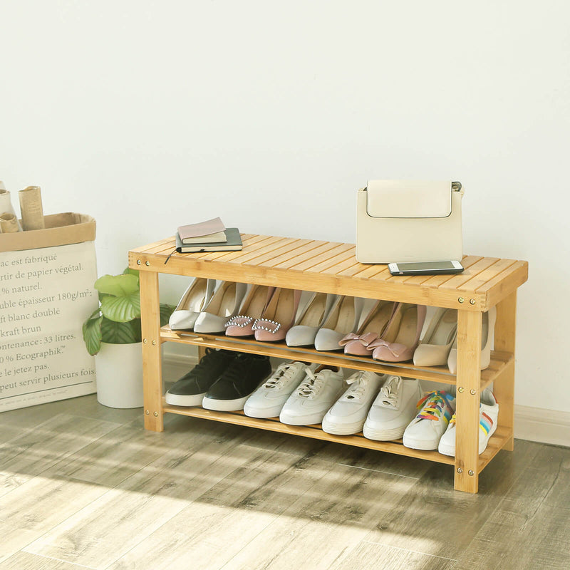 Bamboo shoe bench in a hallway with a bag and phone on top and shoes on both shelves