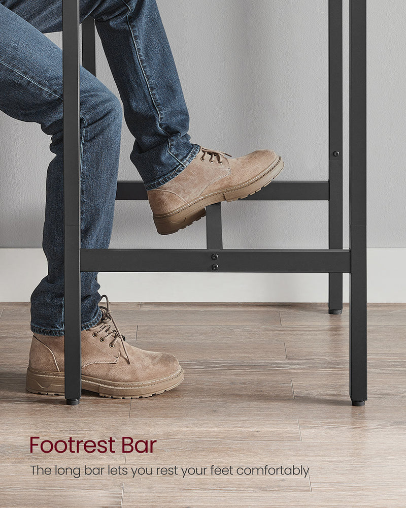 Person resting a boot on the long footrest bar while seated at the table