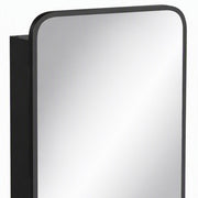 Close-up of the black frame and rounded corner of the mirror cabinet door