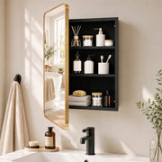 Gold mirror cabinet with the door open showing black shelves with toiletries beside a basin