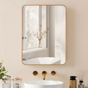 Gold-framed mirror cabinet above a white basin with gold taps