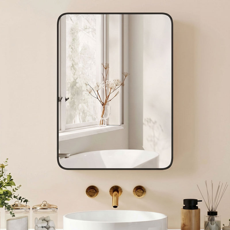 Black-framed mirror cabinet above a white basin with gold taps