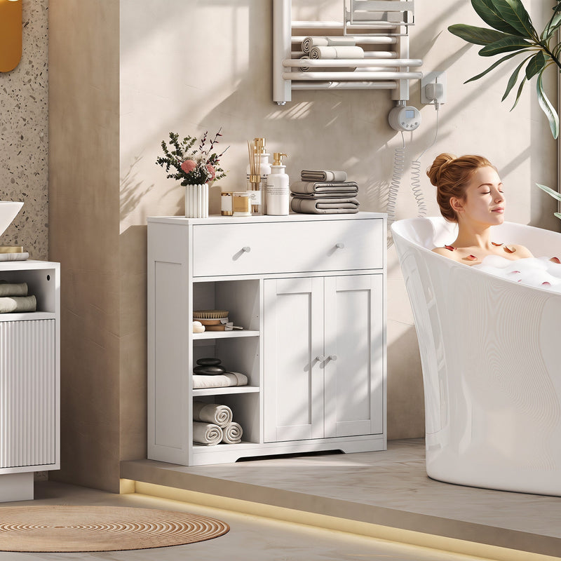 White bathroom cabinet beside a freestanding bath holding rolled towels and toiletries