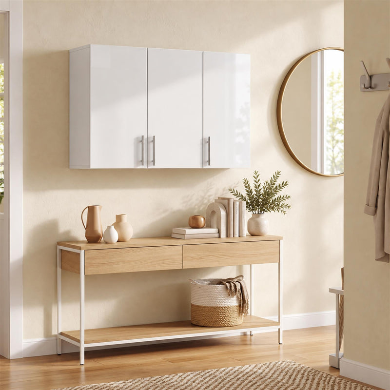 White wall cabinet mounted above a wooden console table in an entryway