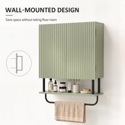 Green wall cabinet fixed to a wall with toiletries below and a towel on the rail, showing the space-saving mount