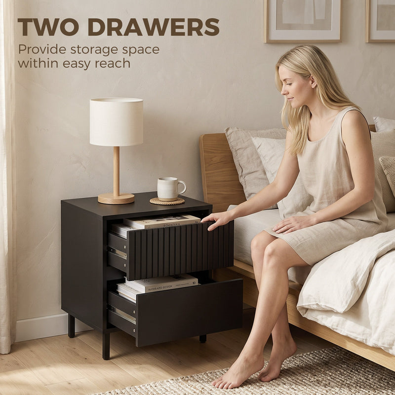 Black bedside cabinet with both drawers open showing storage space beside a bed