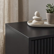 Close-up of black bedside cabinet's tabletop corner and finish