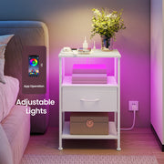 White bedside table beside a bed glowing pink, with a phone showing the app used to adjust the LED light