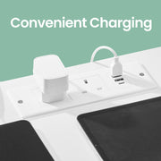 Close-up of the white charging panel set into the tabletop, showing two AC sockets alongside USB-A and USB-C ports