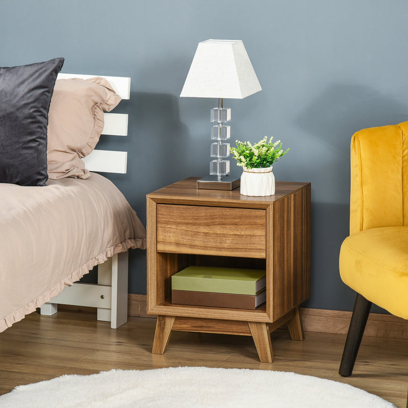 Bedside table next to a bed with a lamp and plant