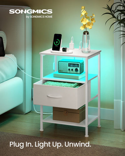 Cloud White bedside table styled in a living room with turquoise LED light glowing under the open shelf and a phone charging on top