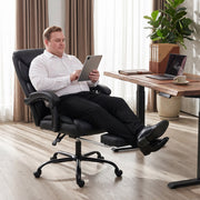 Man reclining with a tablet in the black office chair with the footrest extended