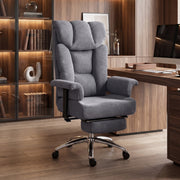 Dark grey high-back massage office chair in a home study with shelves behind