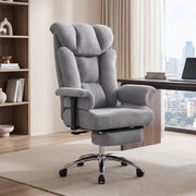 Grey massage office chair with footrest in a home office beside a bookshelf and desk