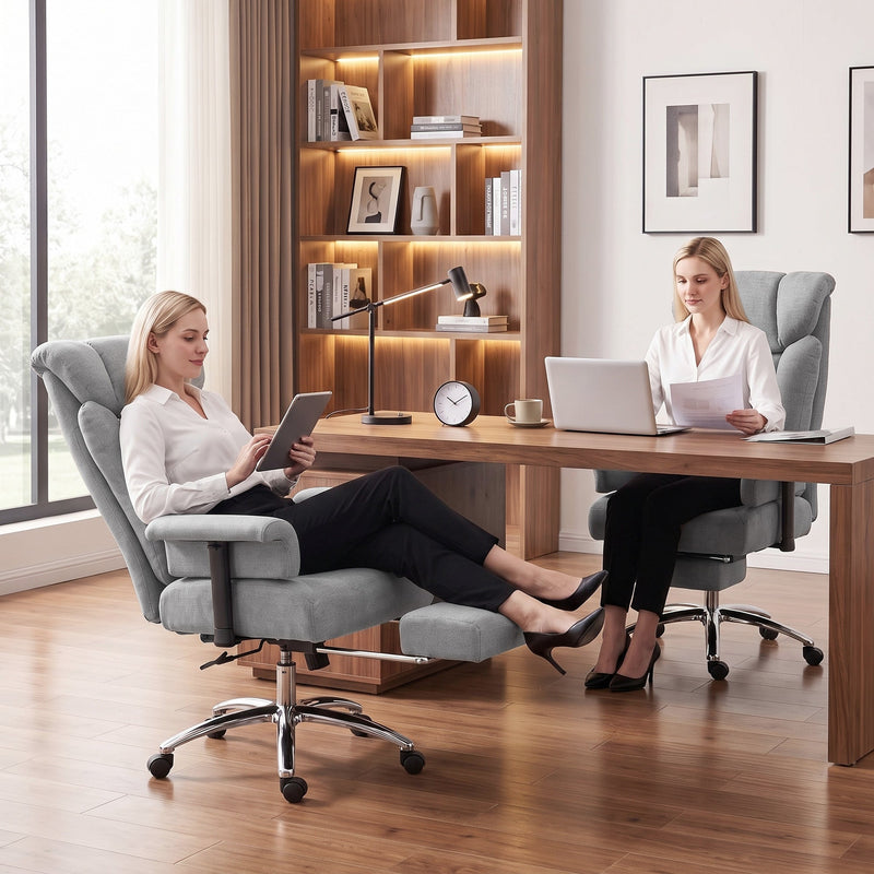 Two women working in grey office chairs, one reclined with the footrest extended