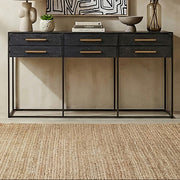 Black 6-drawer console table with gold handles styled in a hallway setting