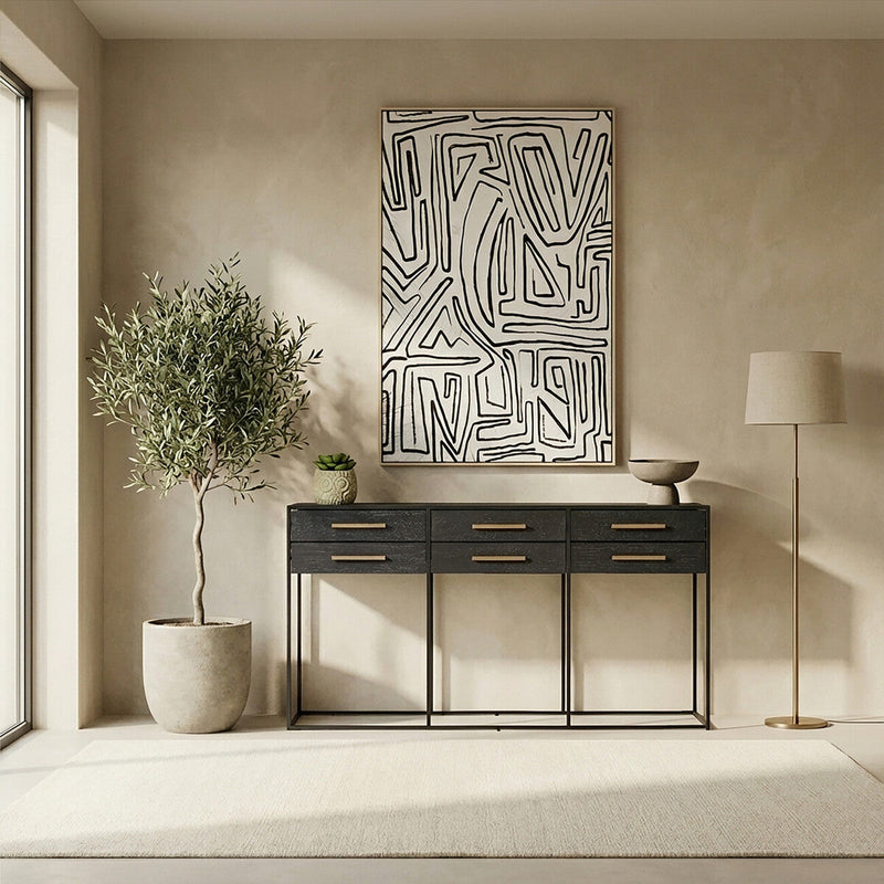 Black 6-drawer console table styled in an entryway with a mirror hung above