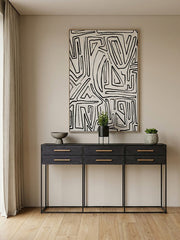 Room setting showing the console table against a panelled wall with decorative accessories