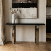 Black ash elm wood console table with silver steel sledge base in a styled room setting