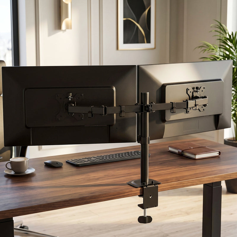 Two monitors on the black dual monitor stand clamped to a wooden desk