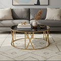 Black glass round coffee table with brushed gold frame styled in a modern living room