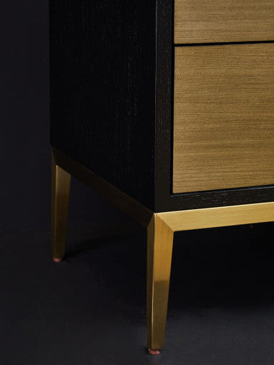Black and gold side table used as an end table beside a reading chair
