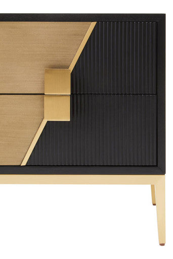 Close-up of the gold-finish handle against the fluted black drawer front