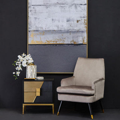 Two drawer side table used as a bedside table beside a bed with a lamp