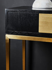 Black and gold console table in a contemporary living room setting
